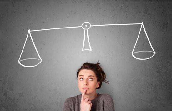 Pretty young lady taking a decision with scale above her head_image